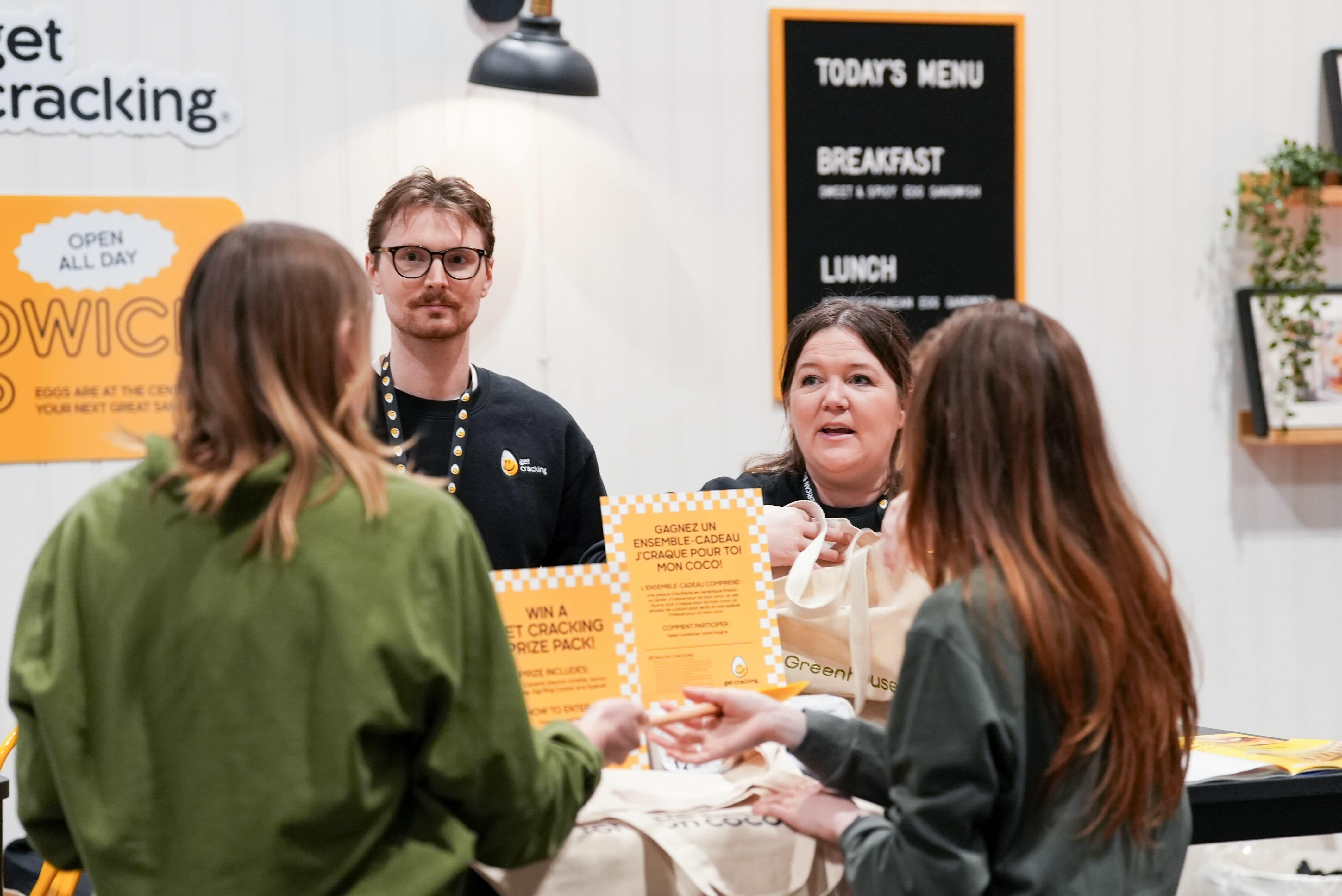 Brand ambassadors speaking to guests at a food trade show booth