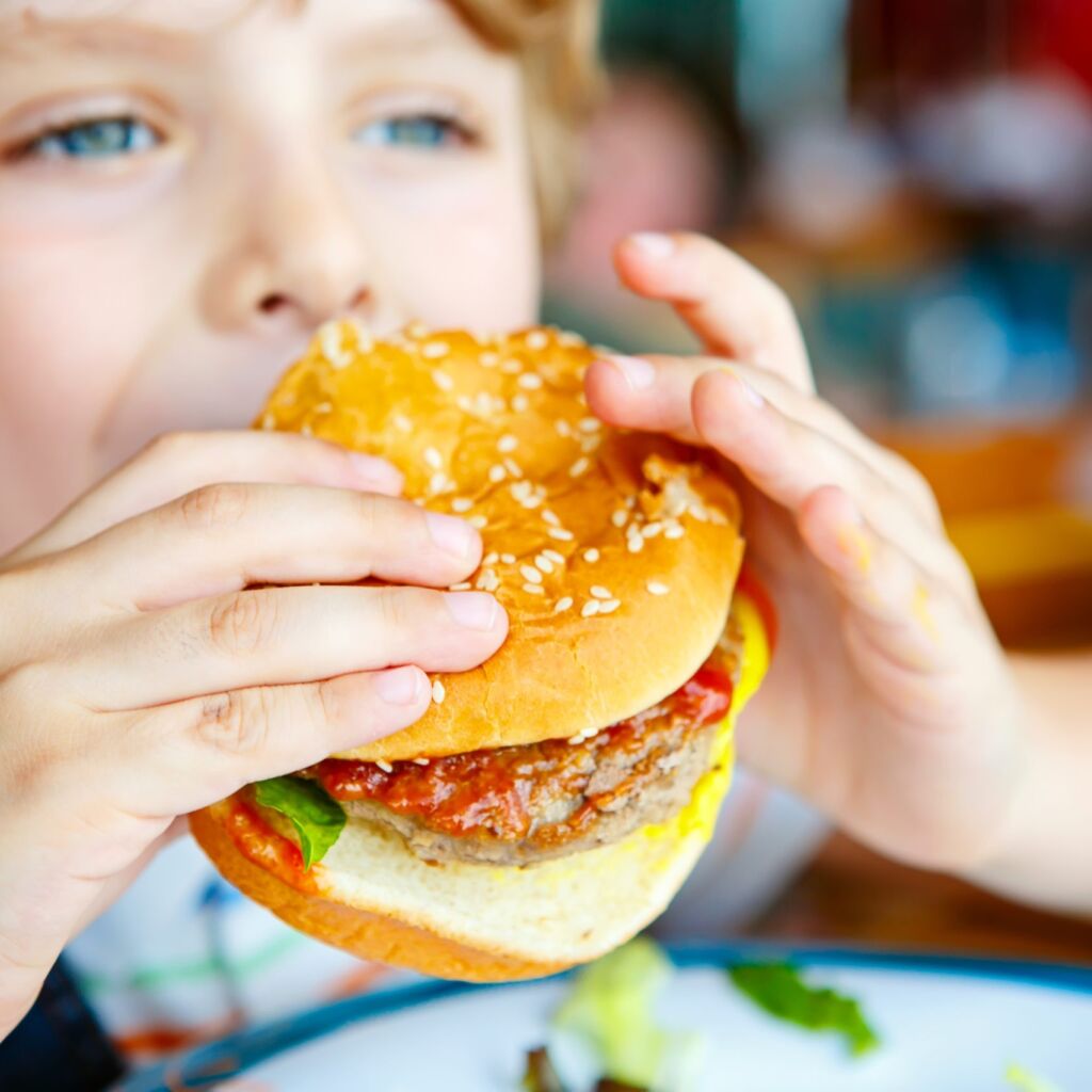 Child eating a burger scaled