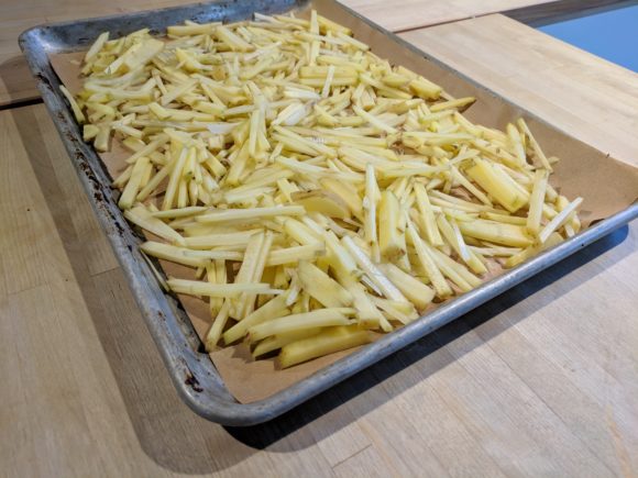 Fresh cut fries on a baking sheet