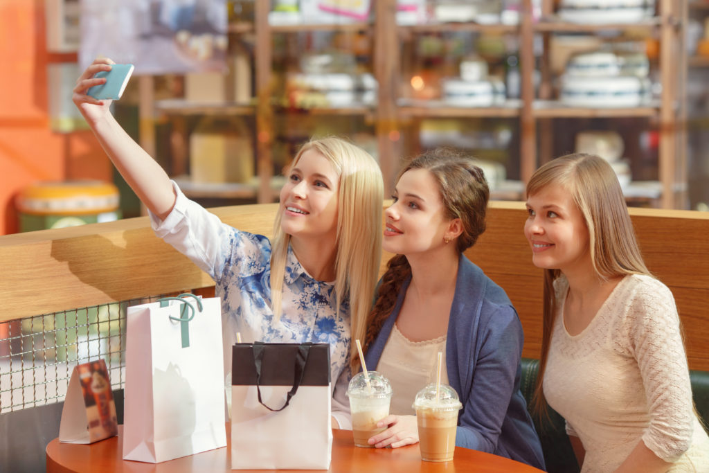 Generation Z girls taking a selfie in a coffee shop